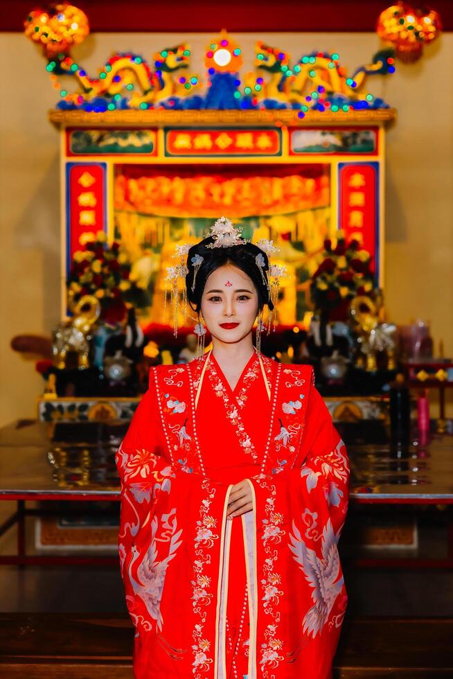 mulher vestir China Novo ano. retrato do uma mulher. pessoa dentro tradicional fantasia. mulher dentro tradicional fantasia. lindo jovem mulher dentro uma brilhante vermelho vestir e uma coroa do chinês rainha posando. foto