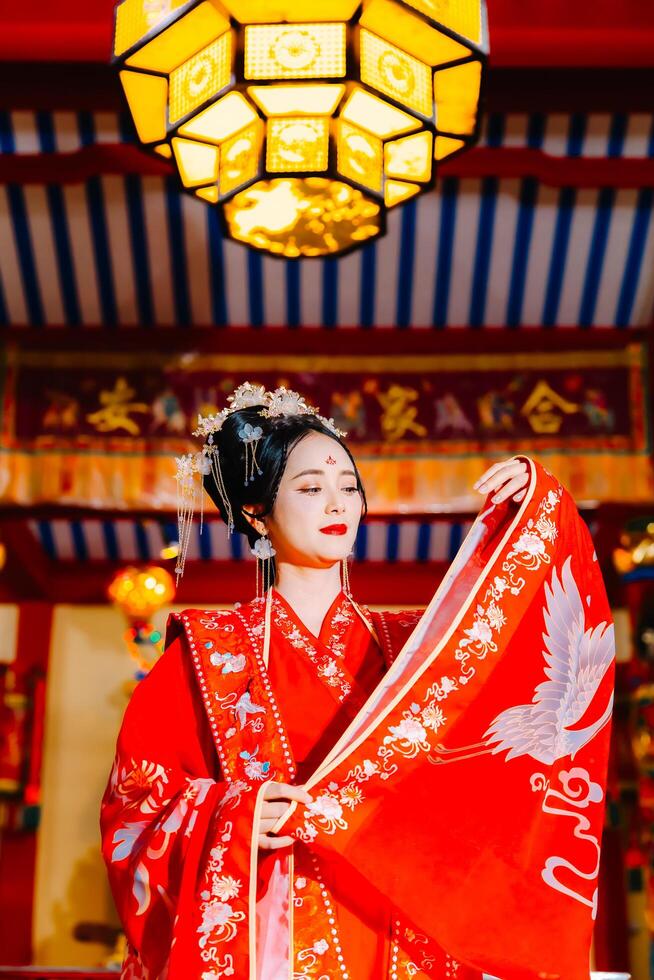 mulher vestir China Novo ano. retrato do uma mulher. pessoa dentro tradicional fantasia. mulher dentro tradicional fantasia. lindo jovem mulher dentro uma brilhante vermelho vestir e uma coroa do chinês rainha posando. foto