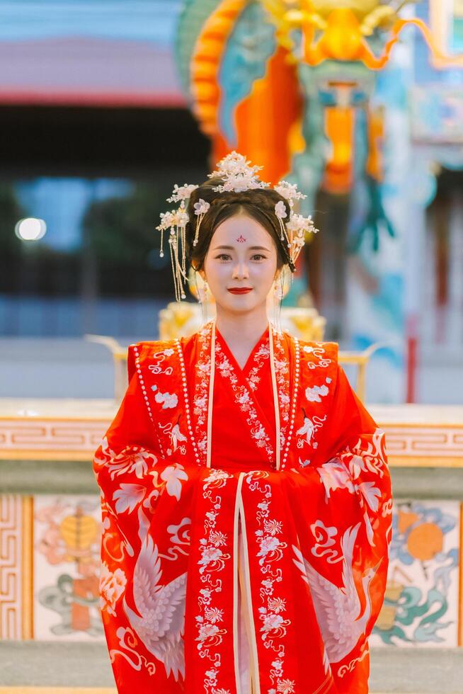 mulher vestir China Novo ano. retrato do uma mulher. pessoa dentro tradicional fantasia. mulher dentro tradicional fantasia. lindo jovem mulher dentro uma brilhante vermelho vestir e uma coroa do chinês rainha posando. foto