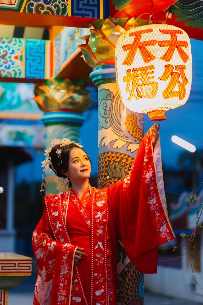 mulher vestir China Novo ano. retrato do uma mulher. pessoa dentro tradicional fantasia. mulher dentro tradicional fantasia. lindo jovem mulher dentro uma brilhante vermelho vestir e uma coroa do chinês rainha posando. foto