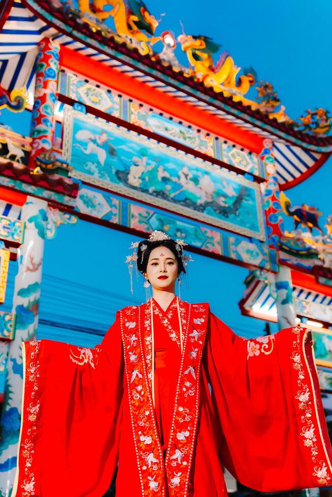 mulher vestir China Novo ano. retrato do uma mulher. pessoa dentro tradicional fantasia. mulher dentro tradicional fantasia. lindo jovem mulher dentro uma brilhante vermelho vestir e uma coroa do chinês rainha posando. foto