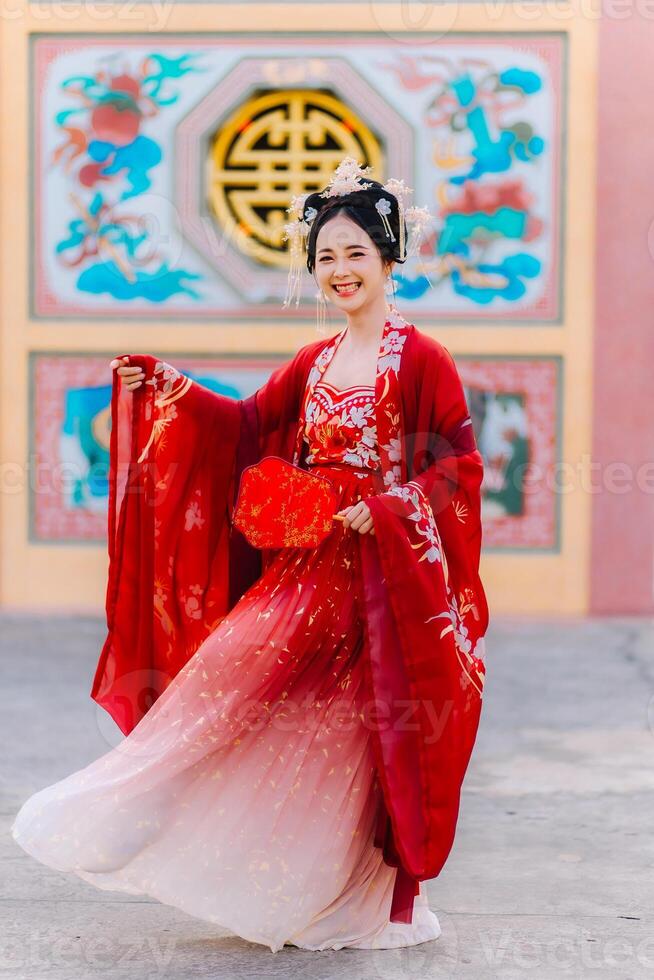 mulher vestir China Novo ano. retrato do uma mulher. pessoa dentro tradicional fantasia. mulher dentro tradicional fantasia. lindo jovem mulher dentro uma brilhante vermelho vestir e uma coroa do chinês rainha posando. foto