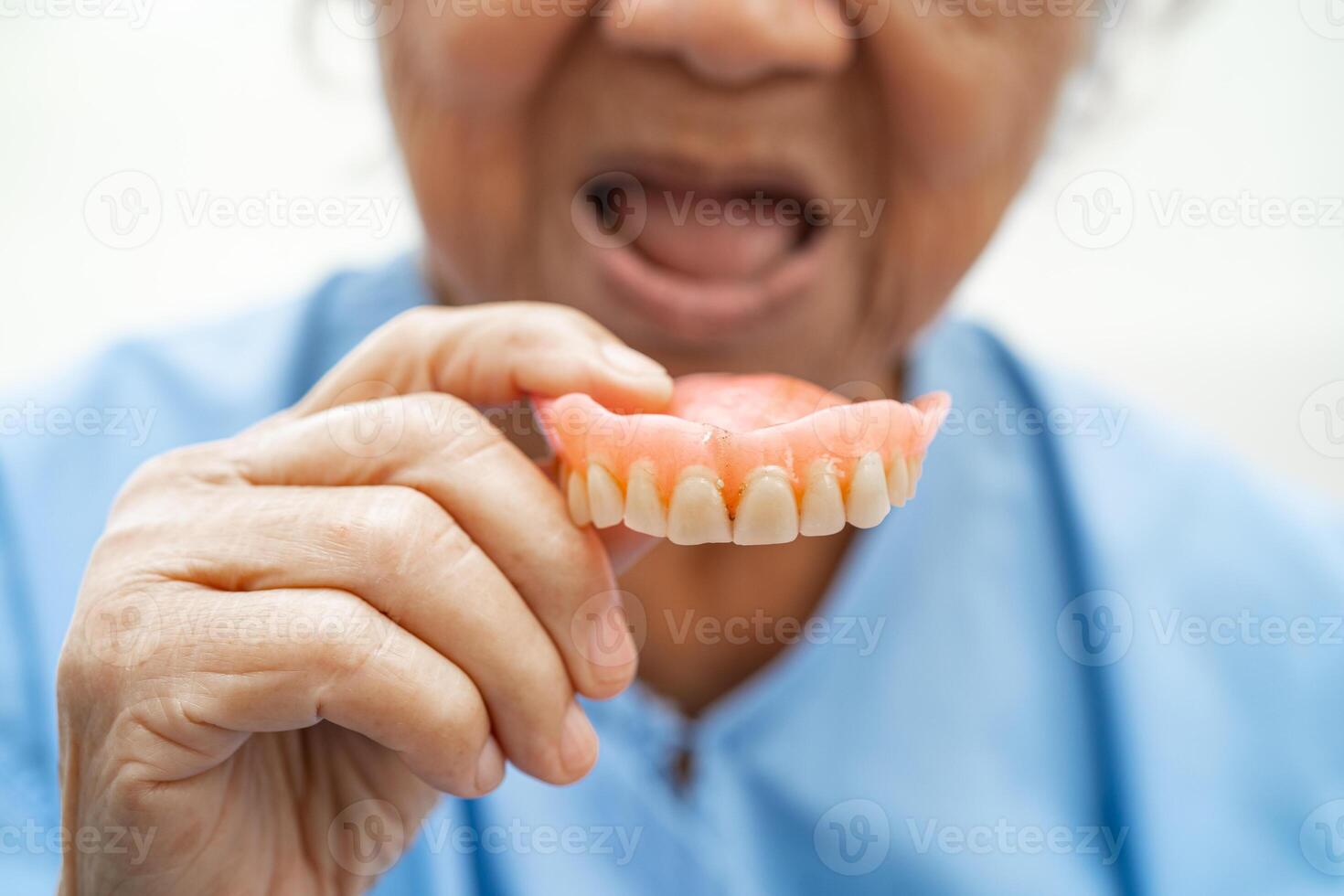 paciente de mulher idosa asiática segurando para usar dentadura, conceito médico forte e saudável. foto