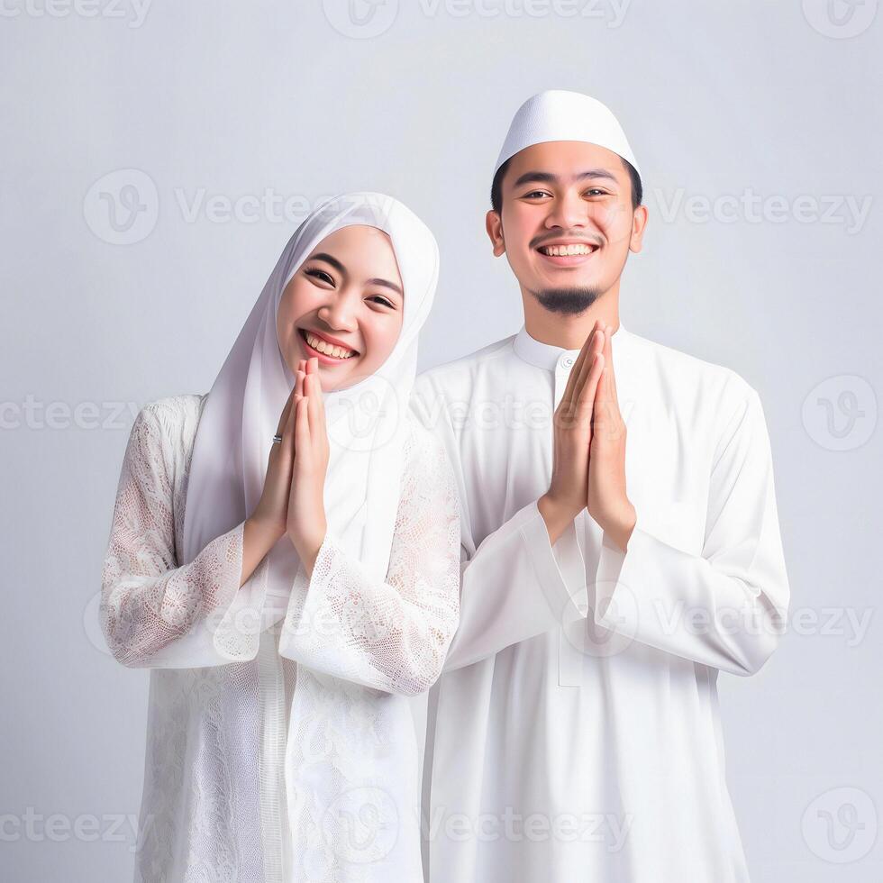 ai gerado comovente retrato do uma jovem ásia muçulmano casal dentro tradicional traje, Incluindo hijab, trocando alegre eid Mubarak gestos dentro uma estúdio configuração com uma neutro cor paleta foto