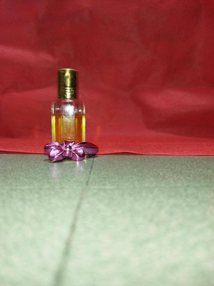 uma pequeno garrafa do perfume sentado em uma vermelho pano foto