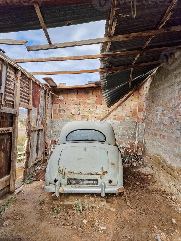 oxidado velho vintage carro dentro a abandonado garagem foto