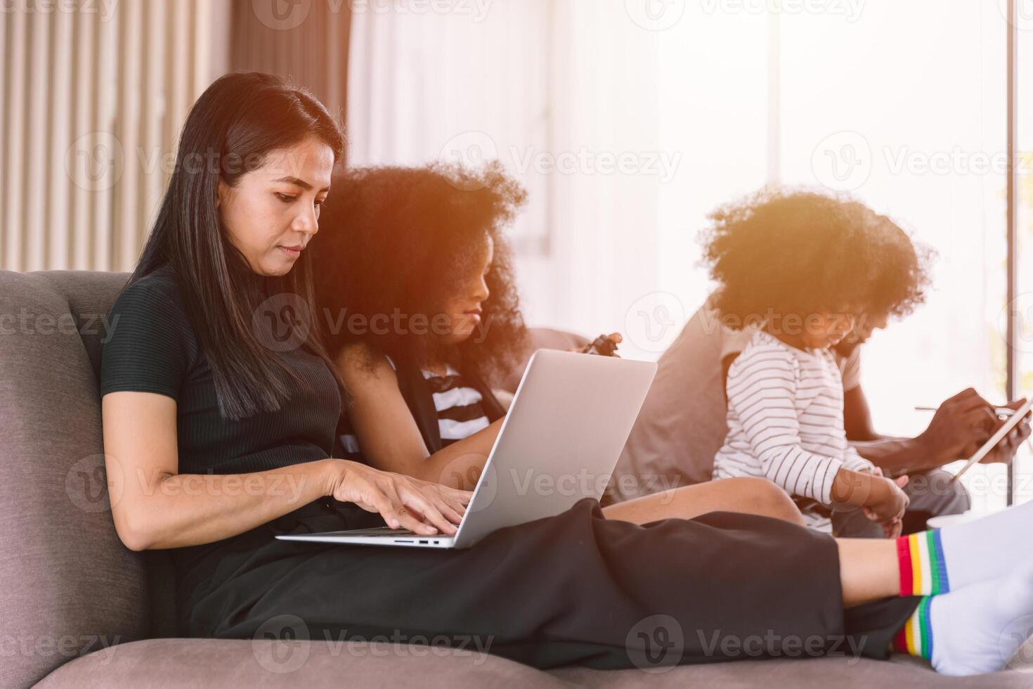 o negócio mãe trabalhando mulher ocupado mãe feriado sem fio trabalhos em computador portátil computador às casa com filha e família foto