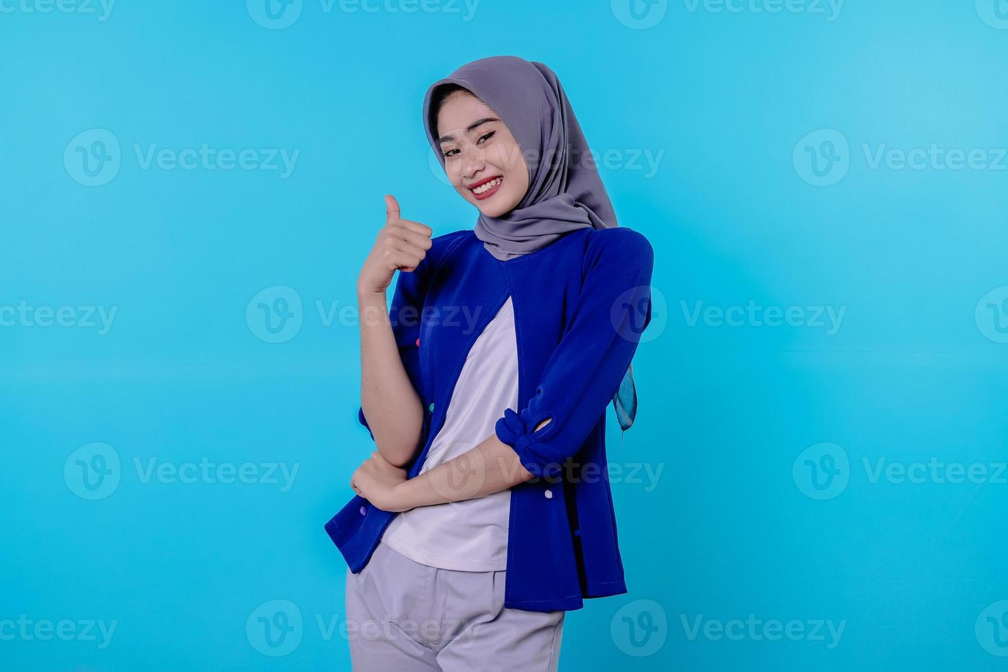 solidária e otimista feliz linda mulher asiática usando hijab polegares para cima, impressionada e encantada foto