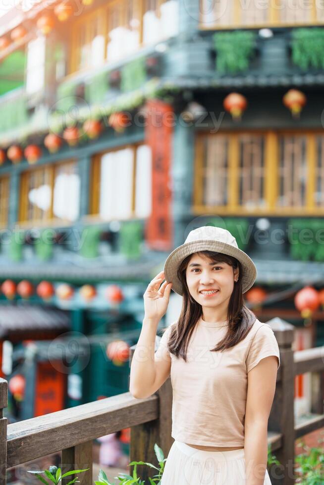 mulher viajante visitando dentro Taiwan, turista com chapéu passeios turísticos dentro Jiufen velho rua Vila com chá casa fundo. ponto de referência e popular atrações perto Taipei cidade . viagem e período de férias conceito foto