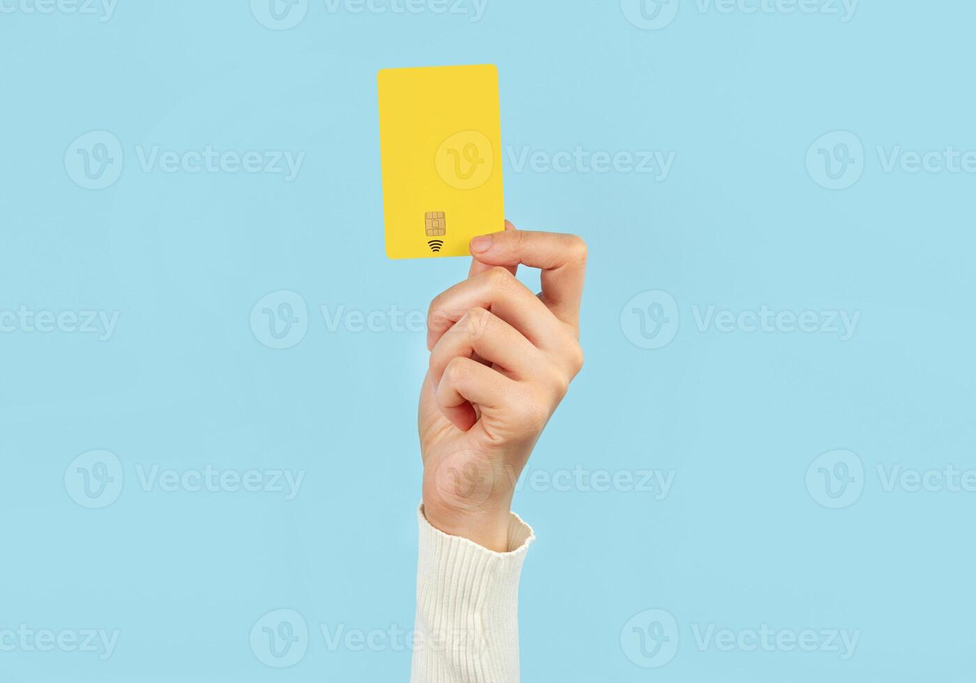 uma fêmea mão detém uma Forma de pagamento cartão em uma azul fundo. conectados serviço. foto
