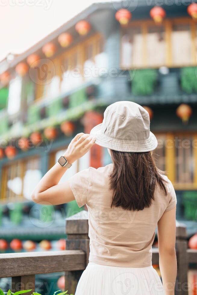 mulher viajante visitando dentro Taiwan, turista com chapéu passeios turísticos dentro Jiufen velho rua Vila com chá casa fundo. ponto de referência e popular atrações perto Taipei cidade . viagem e período de férias conceito foto