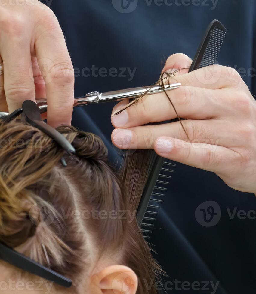 cabeleireiro mãos aguarde tesouras e cortar uma vertente do cabelo para a cliente. seletivo foco.alto qualidade foto