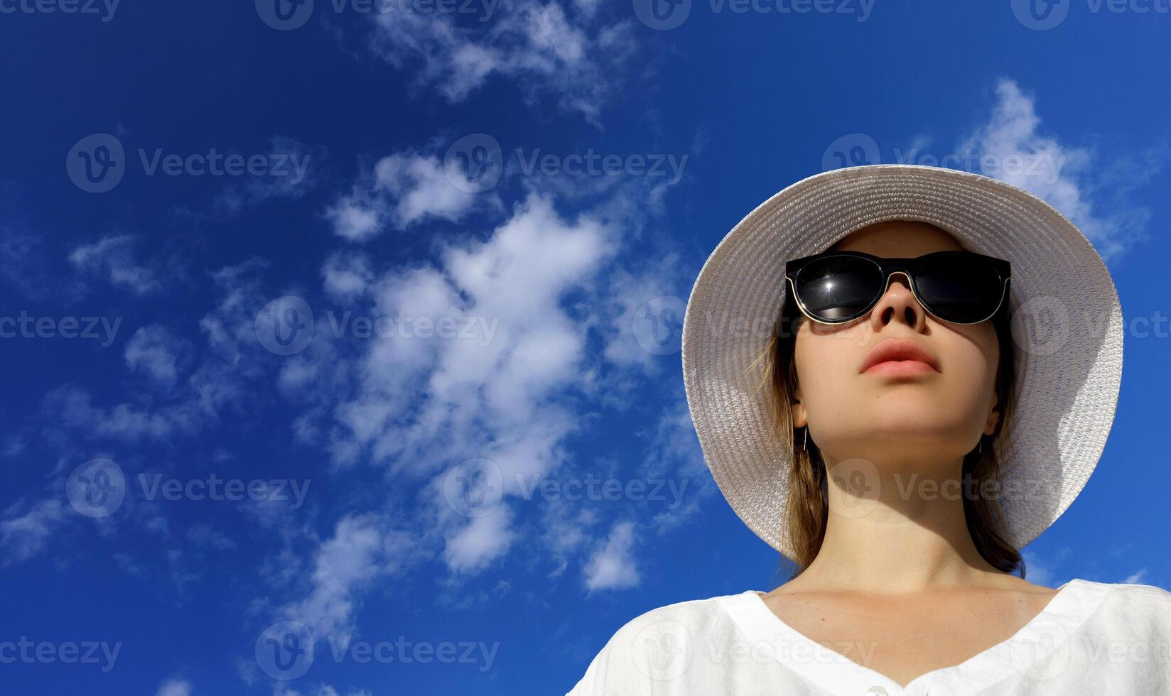 retrato do uma jovem lindo mulher dentro uma Palha chapéu e oculos escuros. Alto qualidade foto