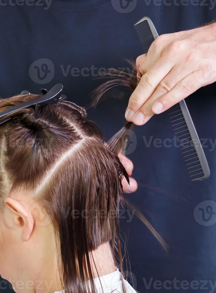 cabeleireiro mãos divisão a cabelo em a cliente cabeça. seletivo foco.alto qualidade foto