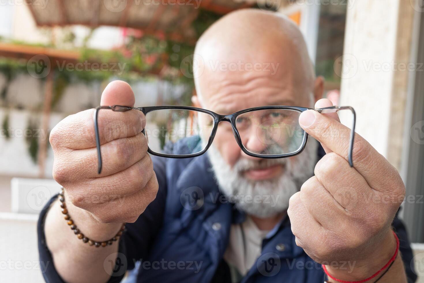 fechar-se retrato do uma bonito adulto homem com uma cinzento barba parece para dentro óculos. foto do Óculos com óculos e quadro, Armação dentro foco. Alto qualidade foto