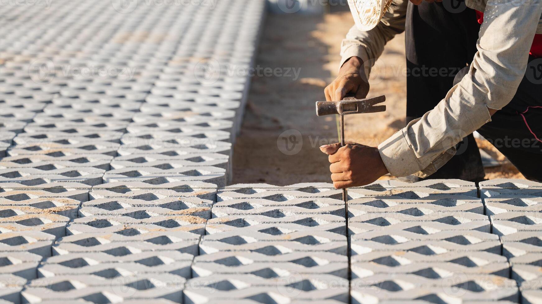 instalando pavimentação blocos conceito. diligente homem envolve dentro ao ar livre construção trabalhar, laboriosamente instalando pavimentação blocos e cimento para crio uma durável e bem elaborado chão em construção local foto