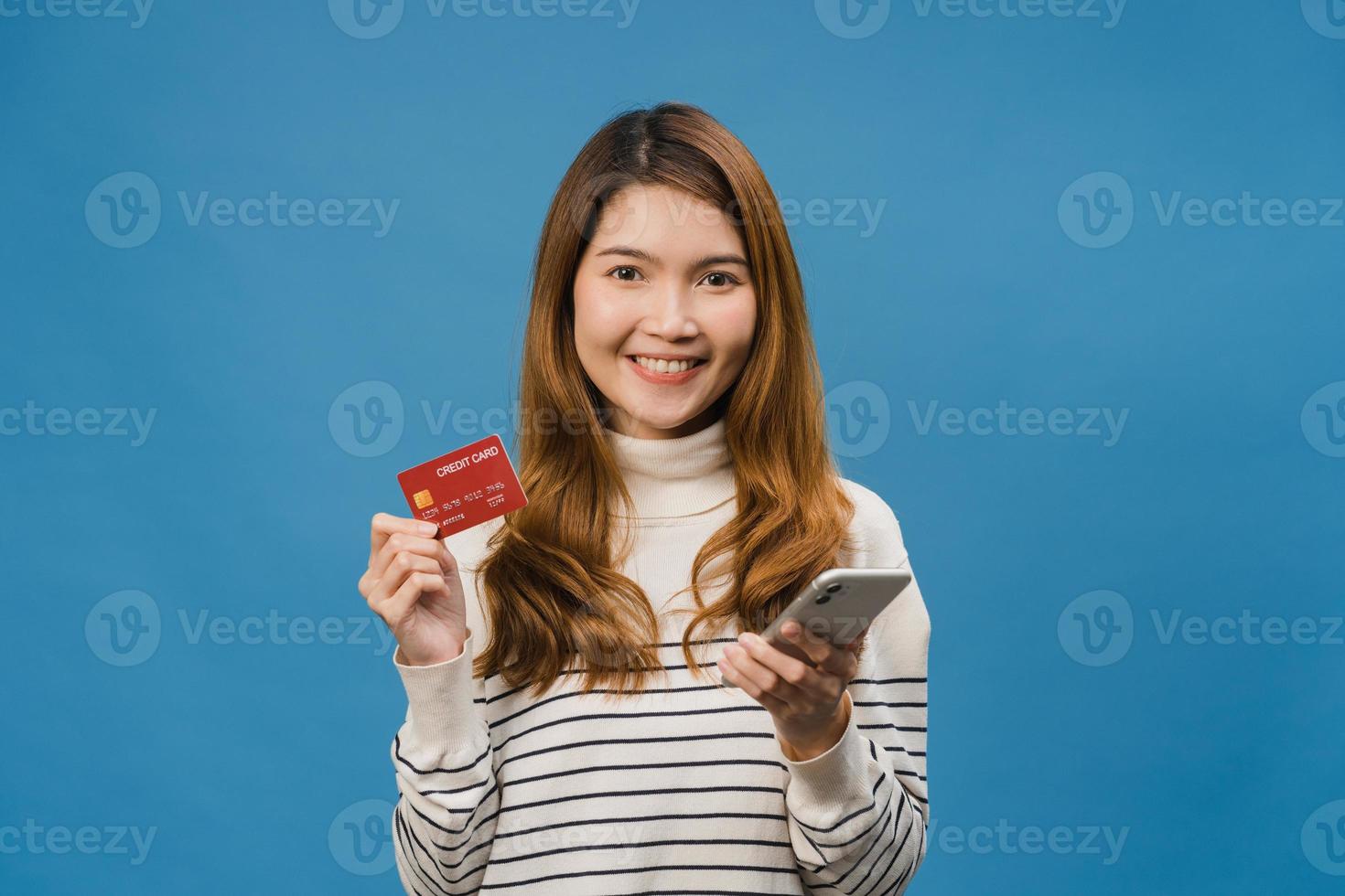 jovem senhora asiática usando telefone celular e cartão de crédito com expressão positiva foto