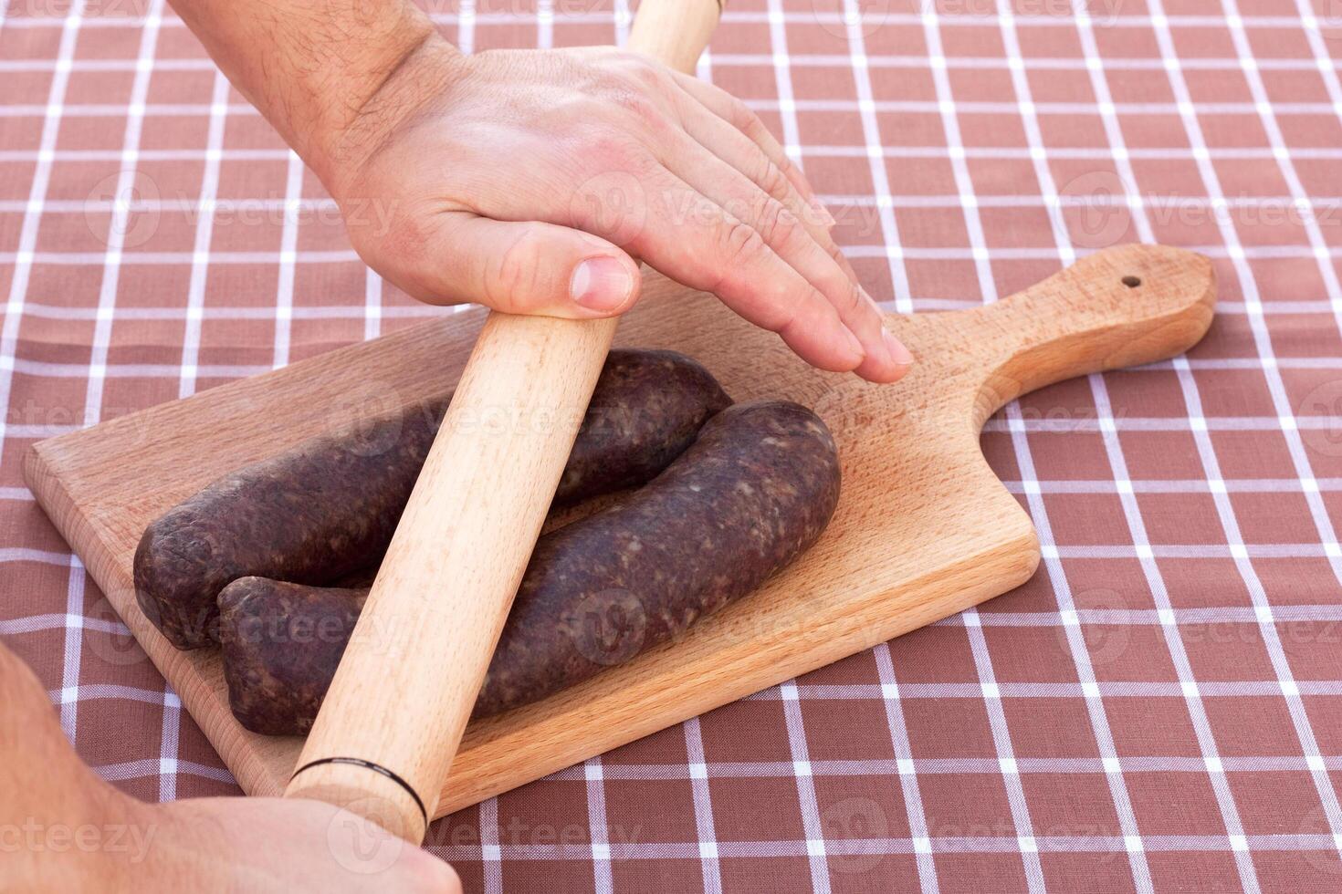 cru salsichas em listra toalha de mesa foto