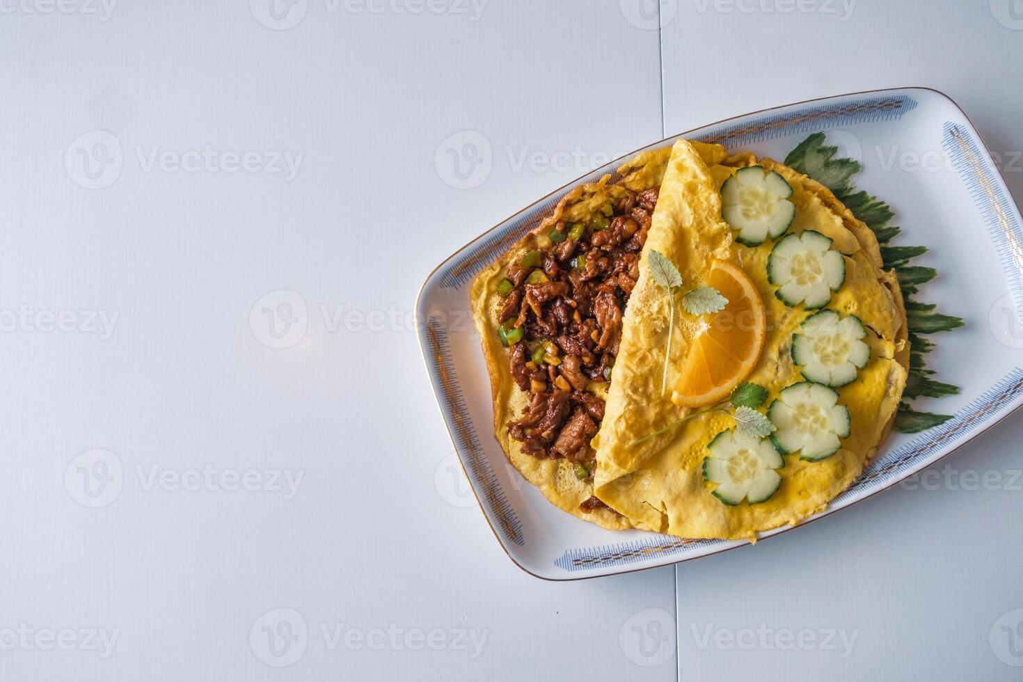 omelete preenchidas carne frito com vegetal em branco mesa foto