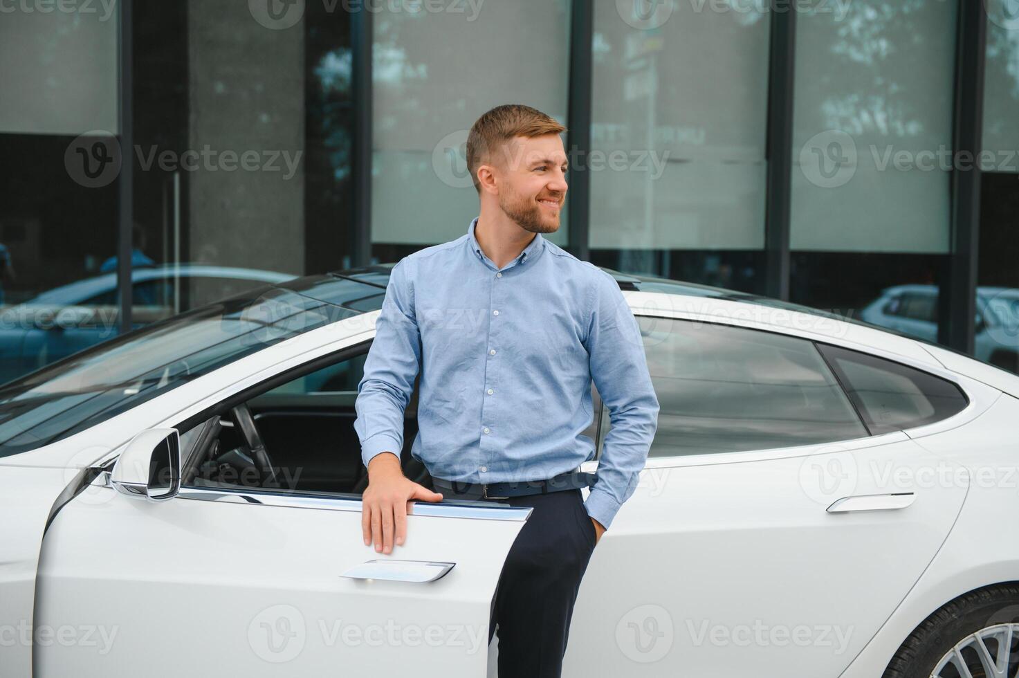 sempre disponível. bonito jovem homem de negocios perto dele carro ao ar livre foto