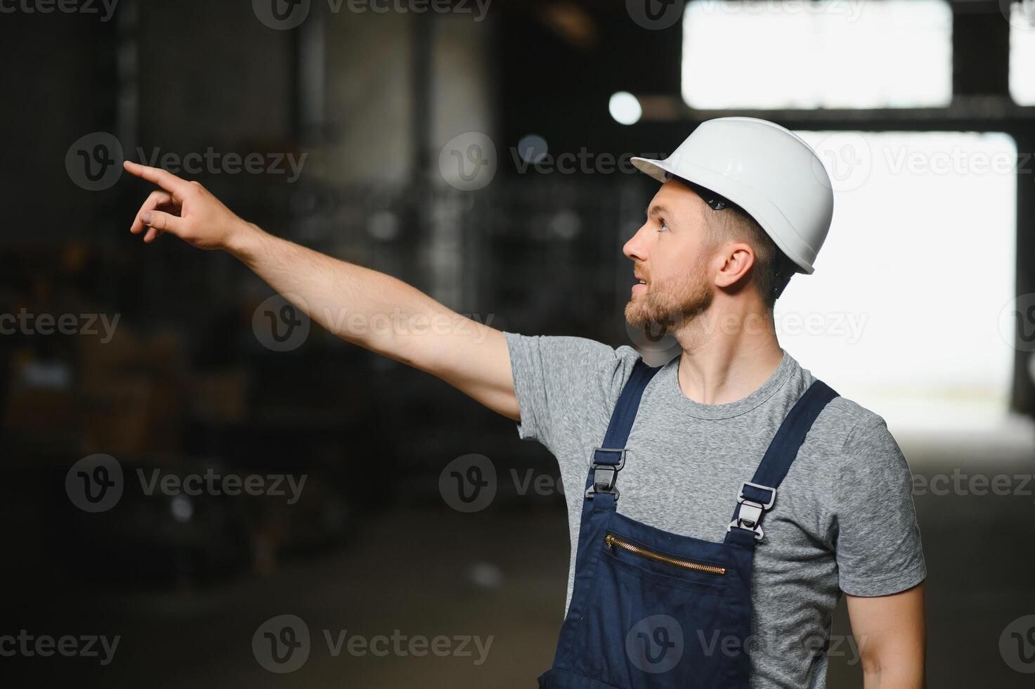 sorridente e feliz funcionário. industrial trabalhador dentro de casa dentro fábrica. jovem técnico com branco Difícil chapéu. foto