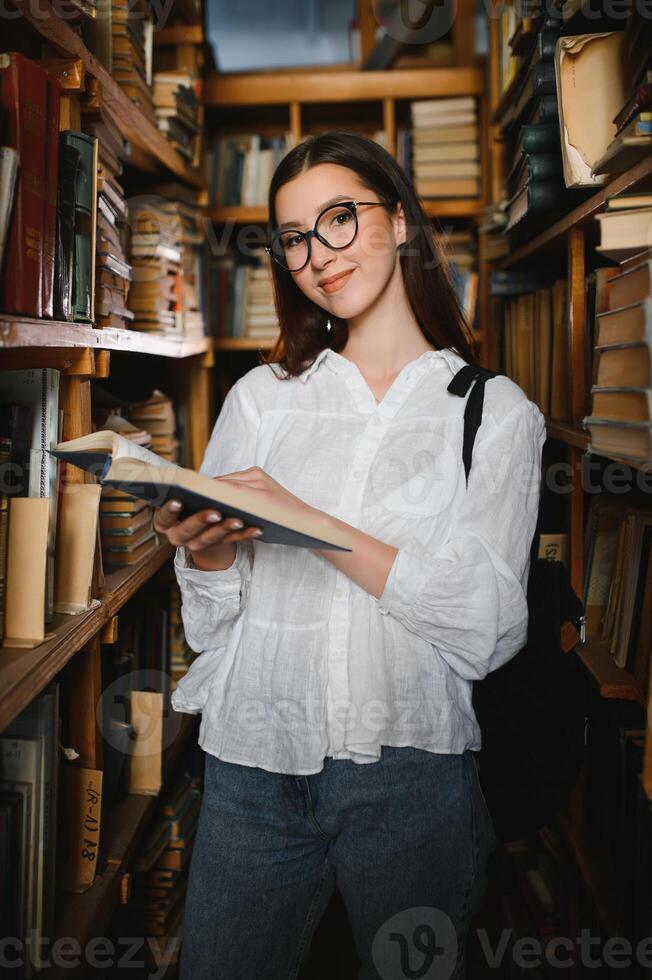 retrato de uma aluna estudando na biblioteca foto