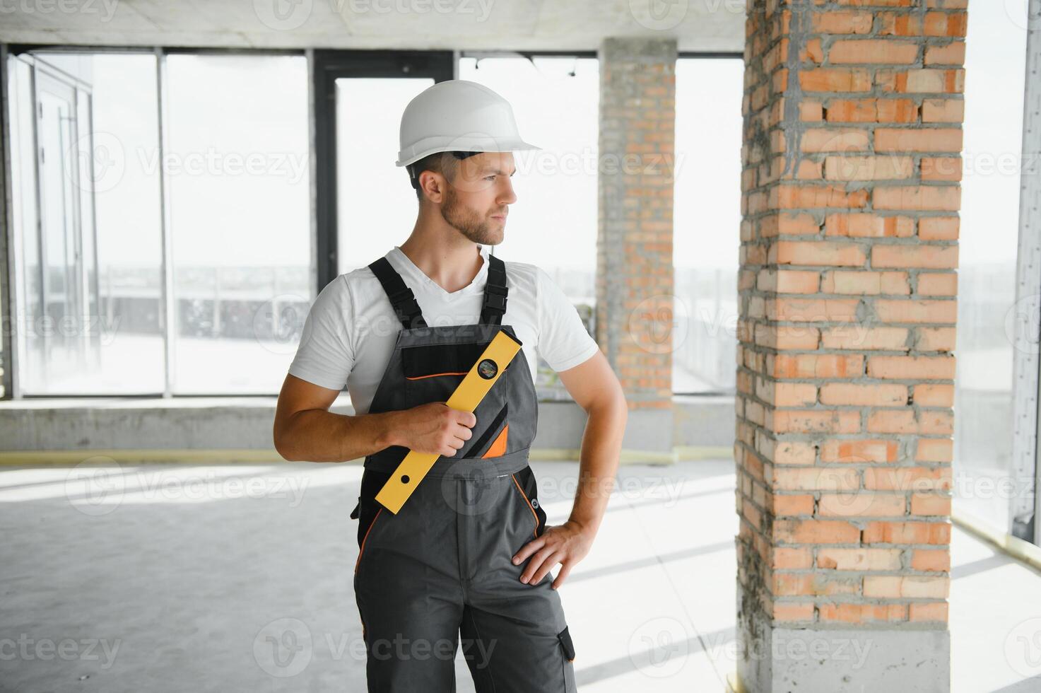 retrato do bonito masculino construtor dentro macacão e Difícil chapéu foto