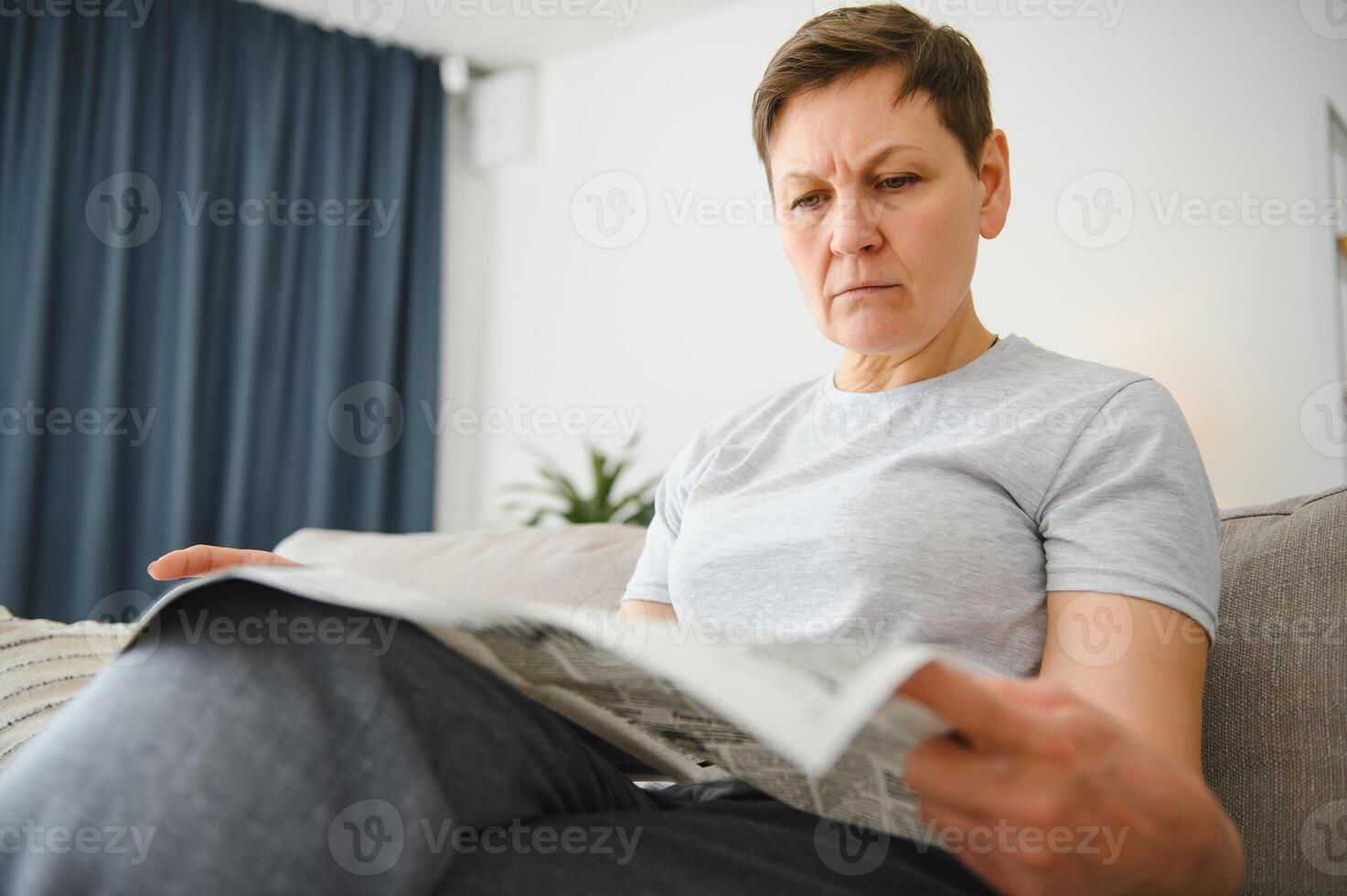 mulher lendo jornal às casa foto