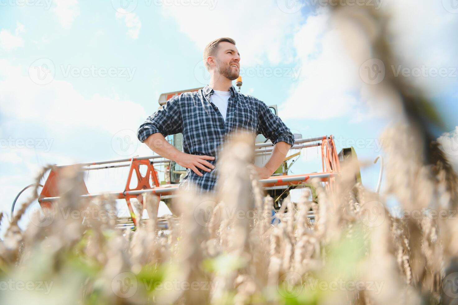 agricultor em pé dentro trigo campo às colheita foto