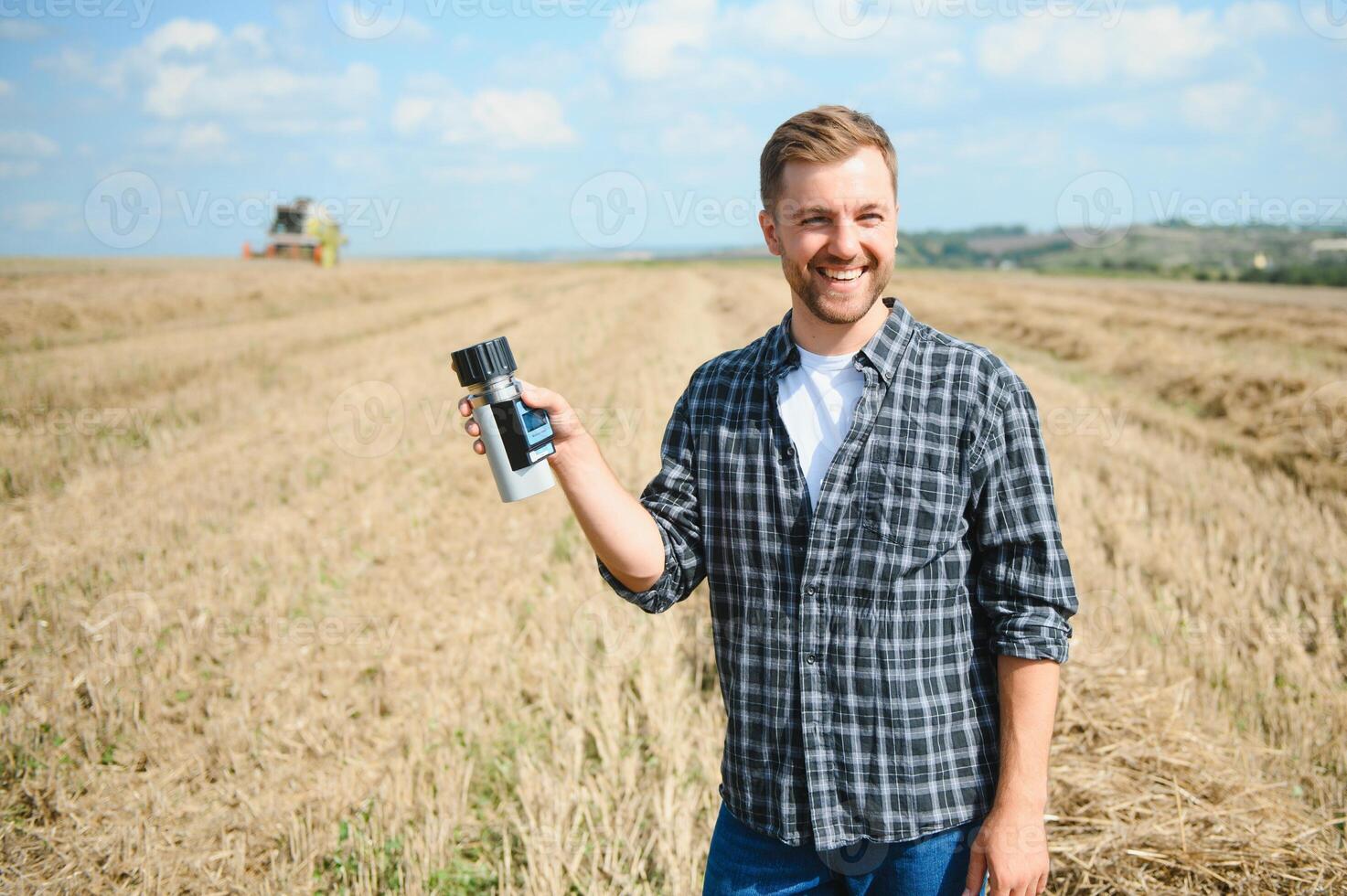 agricultor em pé dentro trigo campo às colheita foto