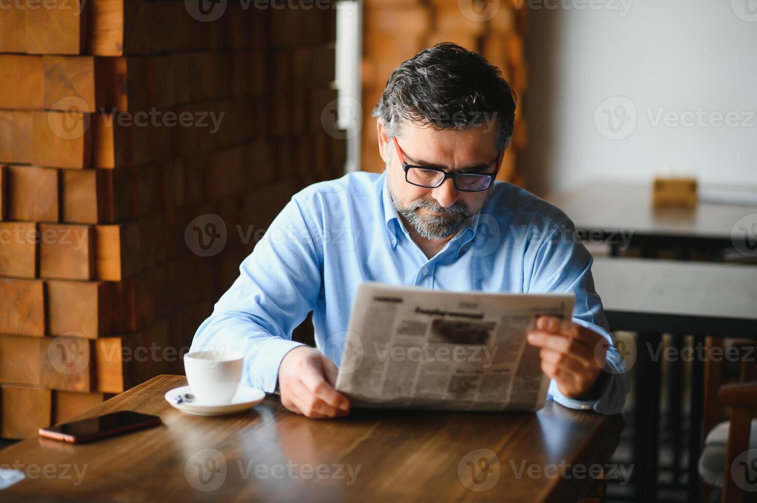 café pausa. homem bebendo café e lendo jornal dentro cafeteria Barra foto