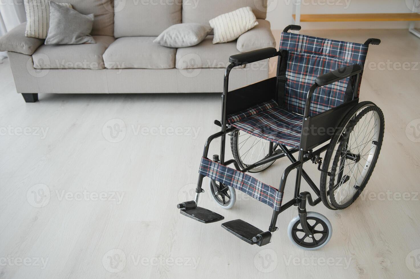 esvaziar cadeira de rodas dentro vivo quarto Próximo para a sofá foto