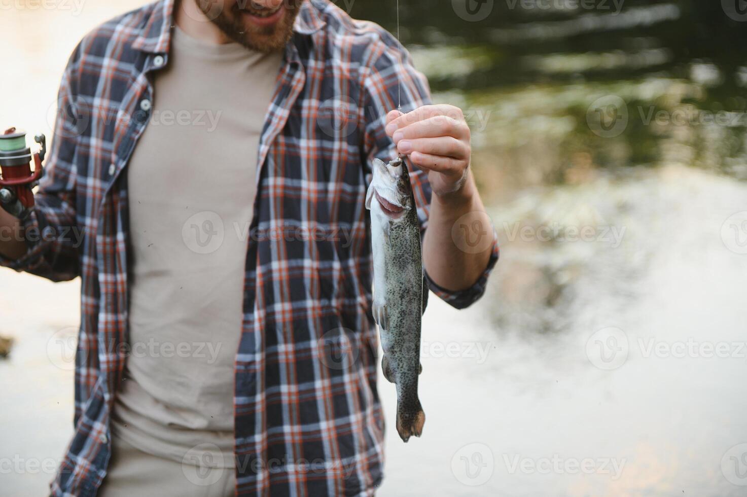 pescador com mosca segurando truta Fora do a água foto