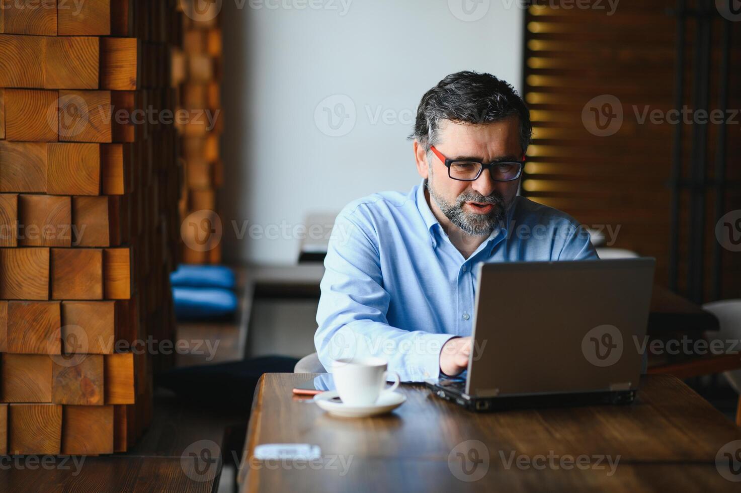 homem usando computador portátil dentro cafeteria Barra foto