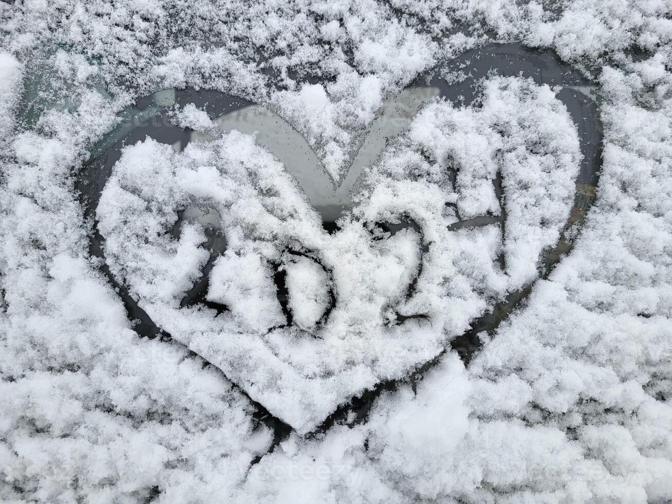 a Novo ano é 2024. uma coração pintado em a parabrisa do uma carro coberto com fresco Natal neve. foto