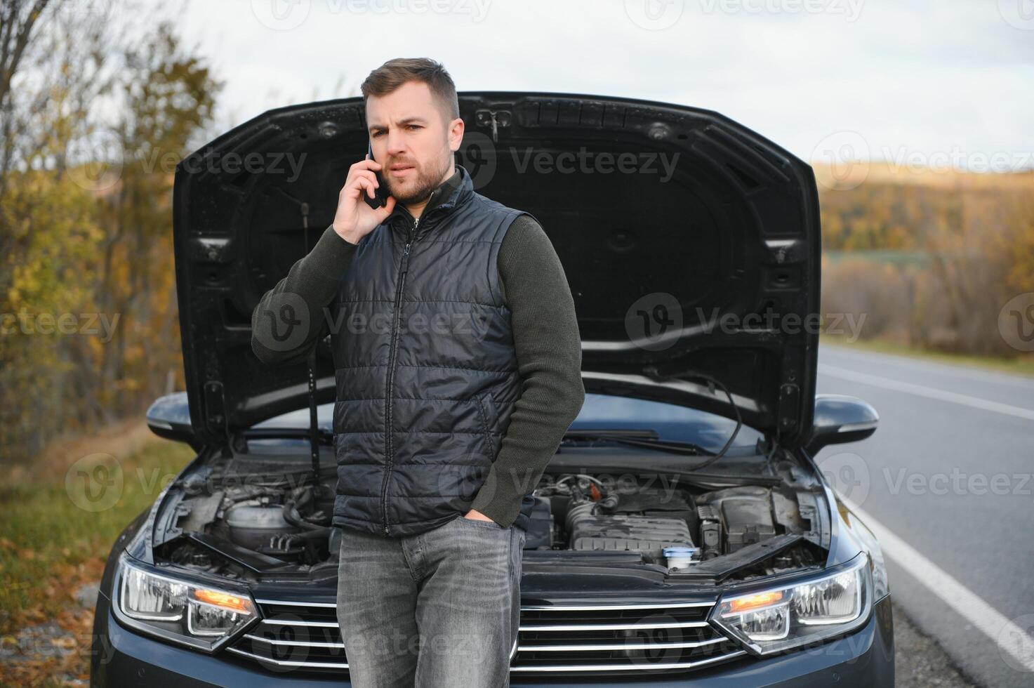 uma homem chamadas uma telefone número para conversa para uma mecânico. a carro quebrou baixa em a na estrada. a conceito para consertar, ajuda, problema, reparar. borrado fundo. foto