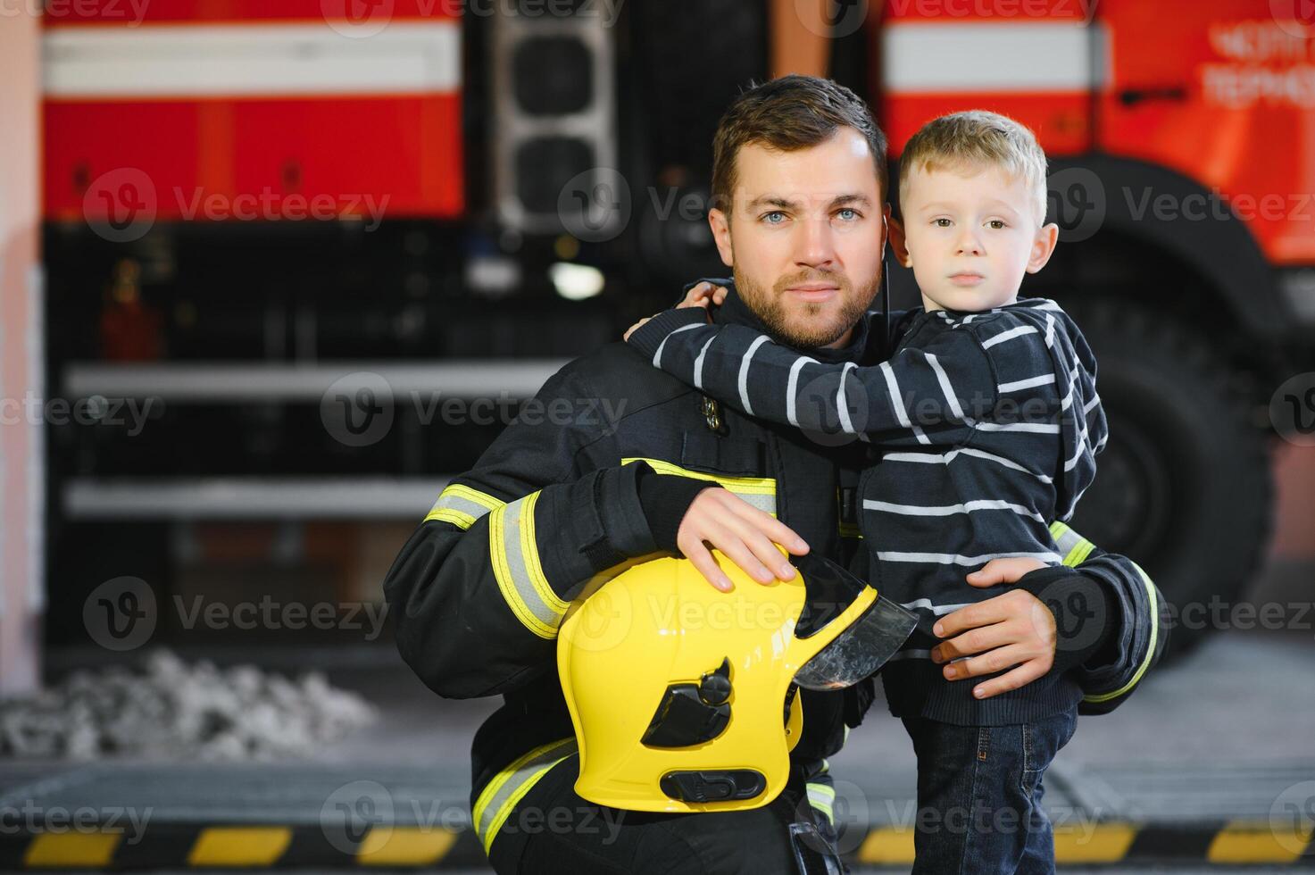 retrato do resgatado pequeno Garoto com bombeiro homem em pé perto fogo caminhão. bombeiro dentro fogo brigando Operação. foto