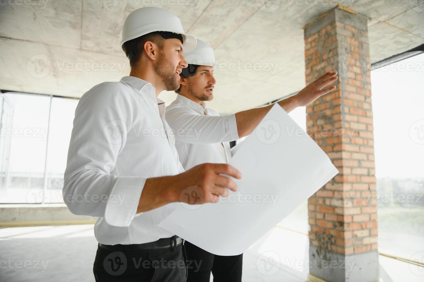 masculino arquiteto dando instruções para dele capataz às construção local. foto