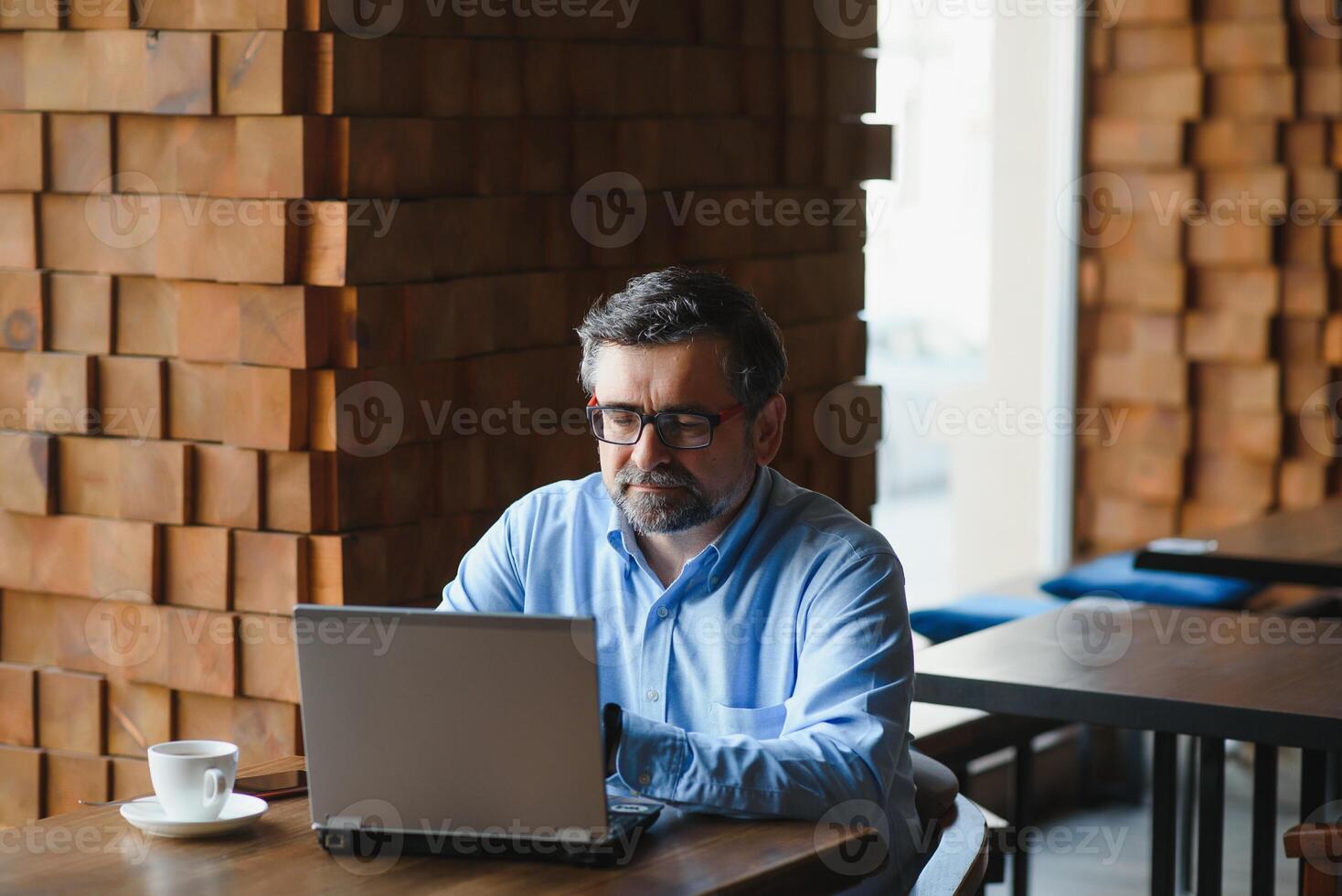 negócios, tecnologia e pessoas conceito , Senior homem de negocios com computador portátil computador bebendo café às moderno cafeteria. foto