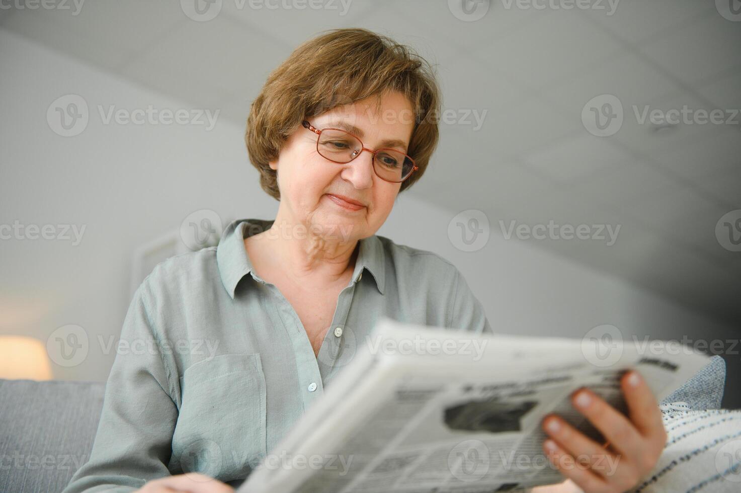 era e pessoas conceito - feliz Senior mulher lendo jornal às casa foto