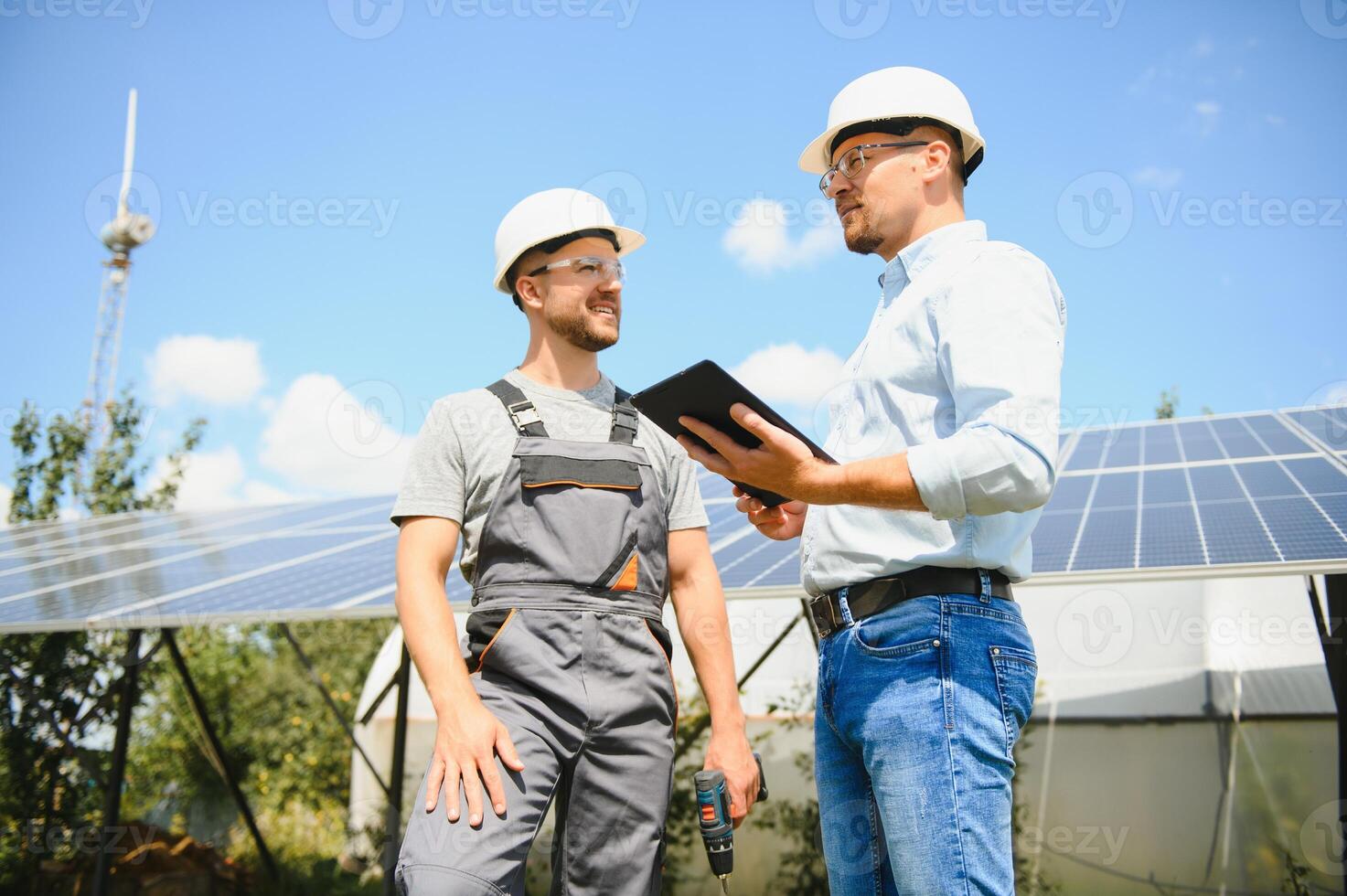 homem de negocios e trabalhador perto solar energia baterias. dois homens fazer acordo. foto