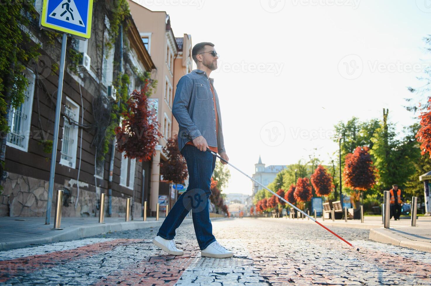 cego cara. pessoas com incapacidade, deficiente pessoa e todo dia vida. visualmente prejudicado homem com caminhando grudar. foto