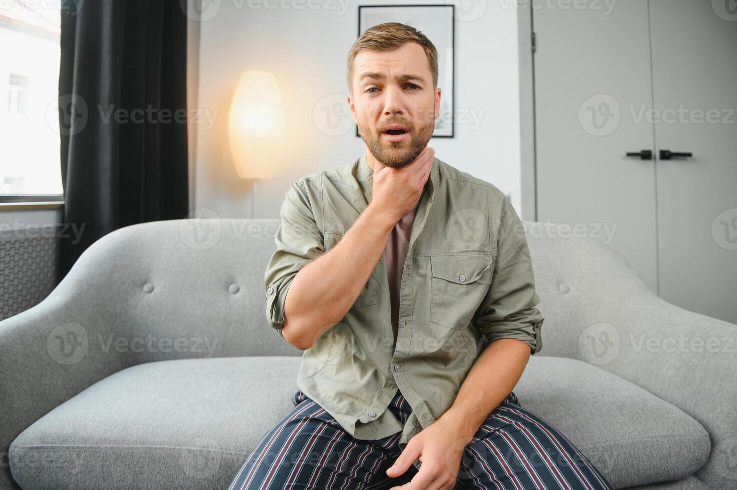 dolorido garganta. cabelos escuros jovem homem tendo uma dolorido garganta. foto