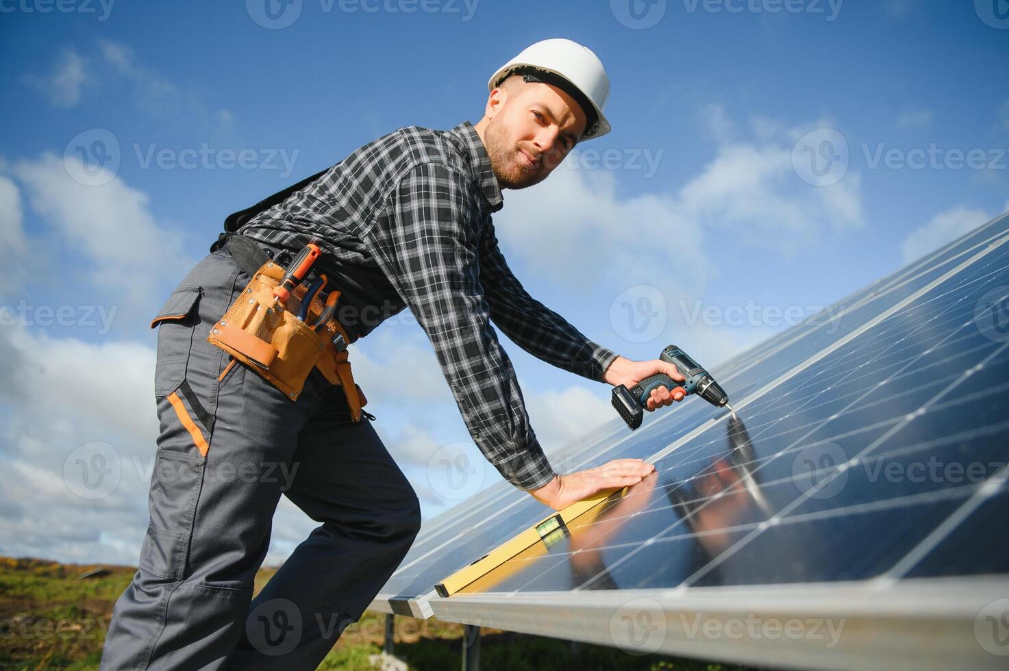masculino trabalhador dentro uniforme ao ar livre com solar pilhas às ensolarado dia. foto