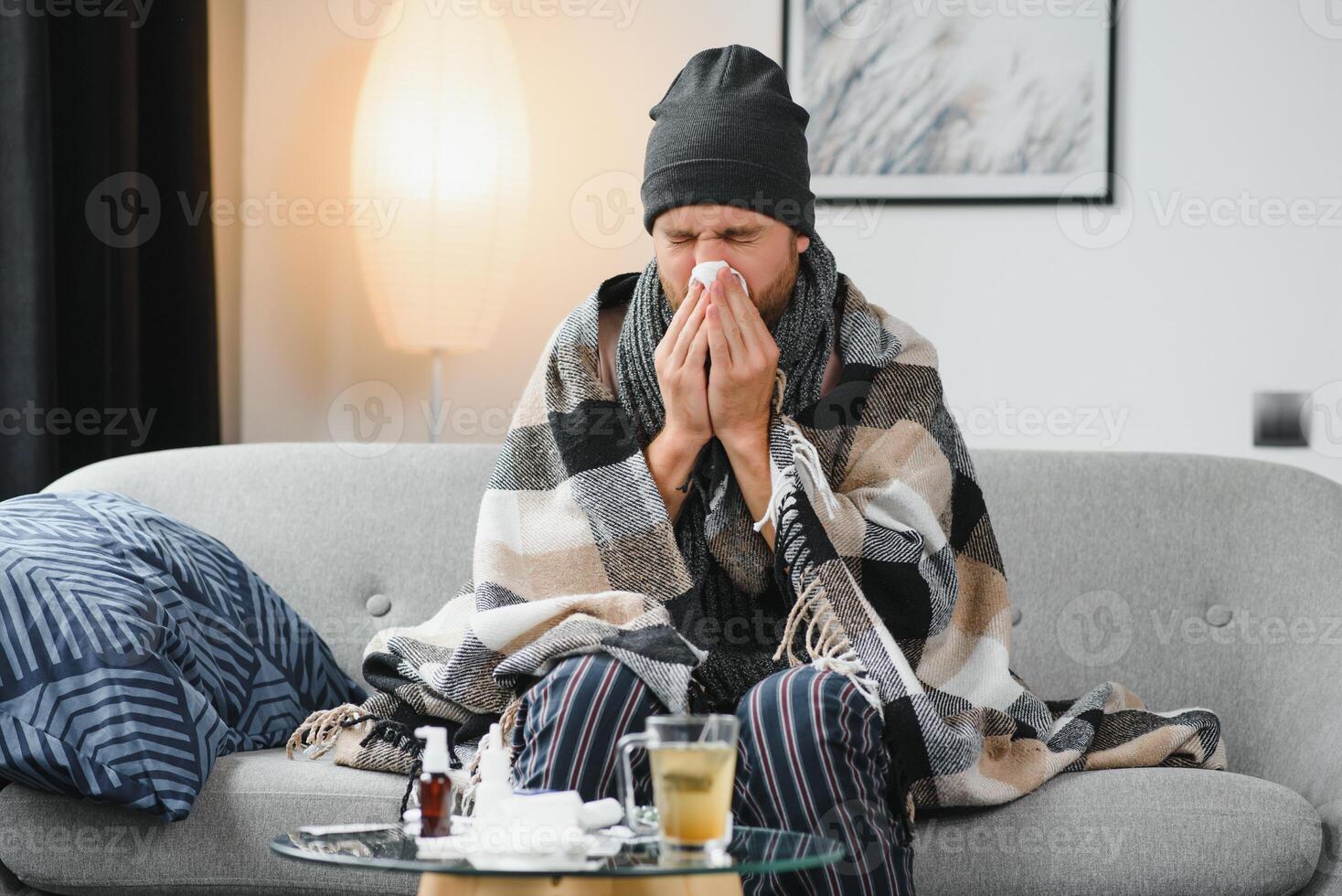 doente triste homem senta em sofá às casa sofre a partir de escorrendo nariz gripe doença coronavírus pandemia cobiçado epidemia espirra. indisposto cara sentindo-me mau febre vírus doença sintomas interior. foto