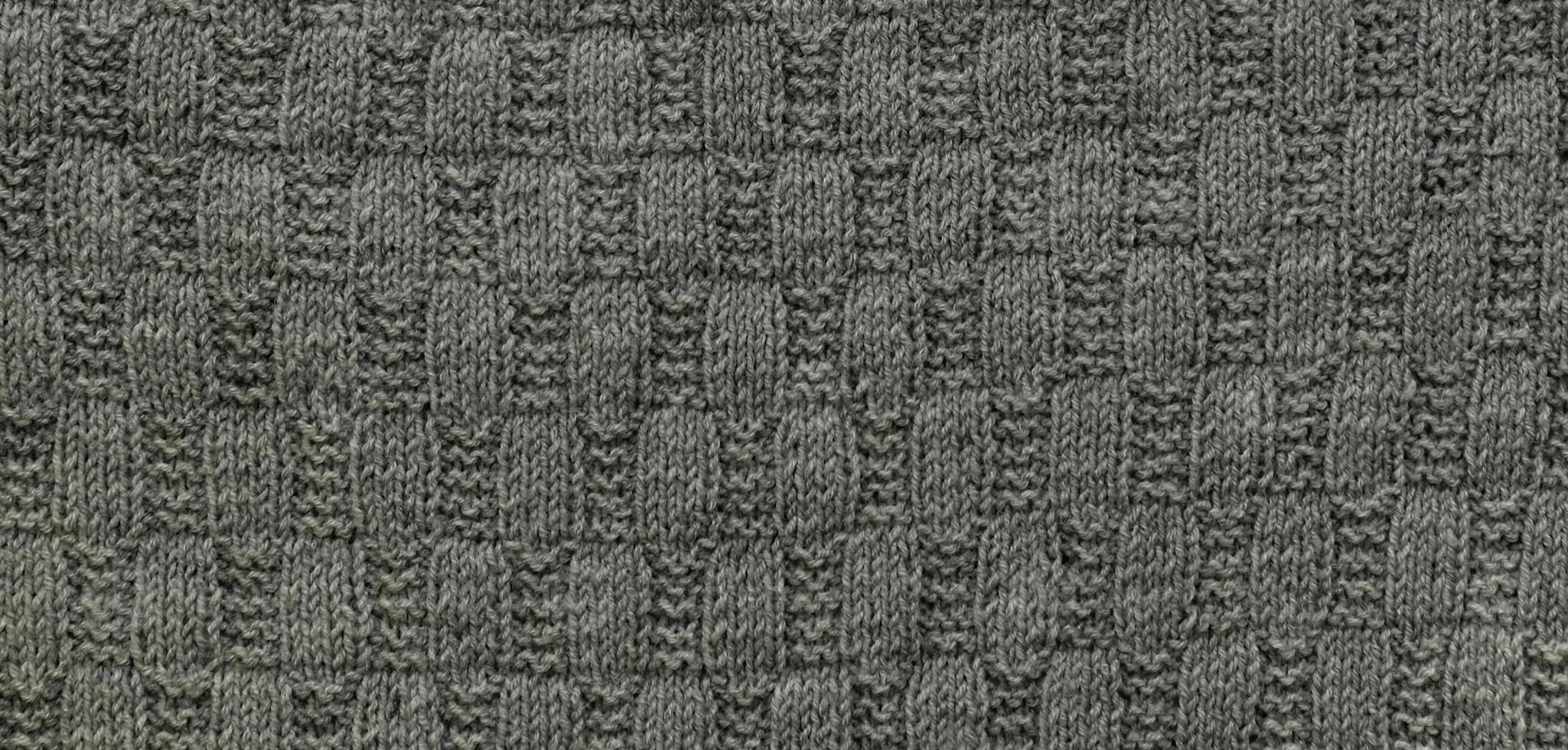 fundo com cinzento tricotado folha forma, tricô padronizar com cabos. topo visualizar, fechar-se. feito à mão tricô lã foto