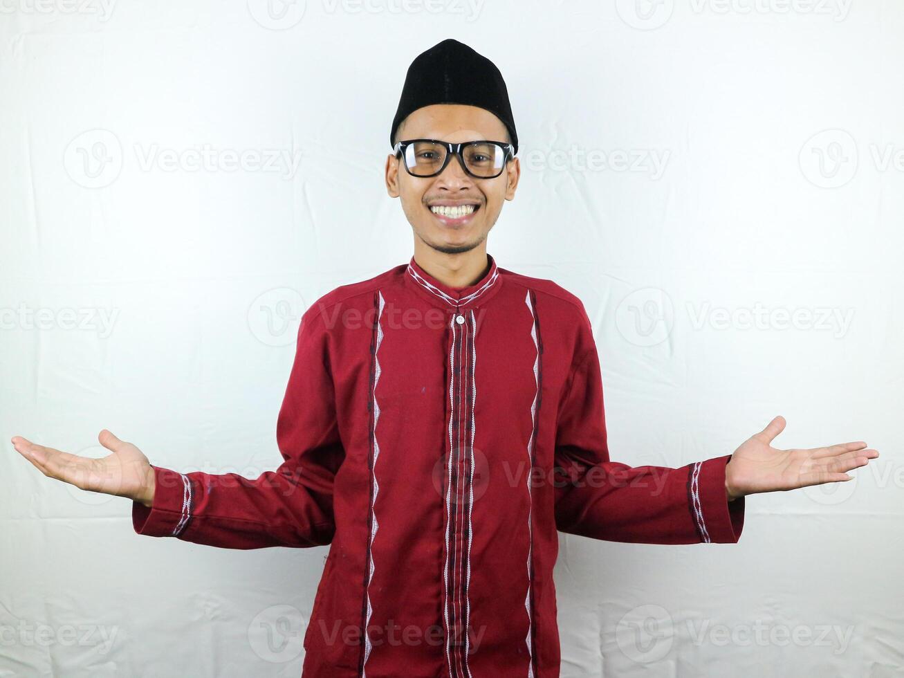 ásia muçulmano homem elevado braços e olhando às Câmera com duvidoso face isolado em branco fundo foto