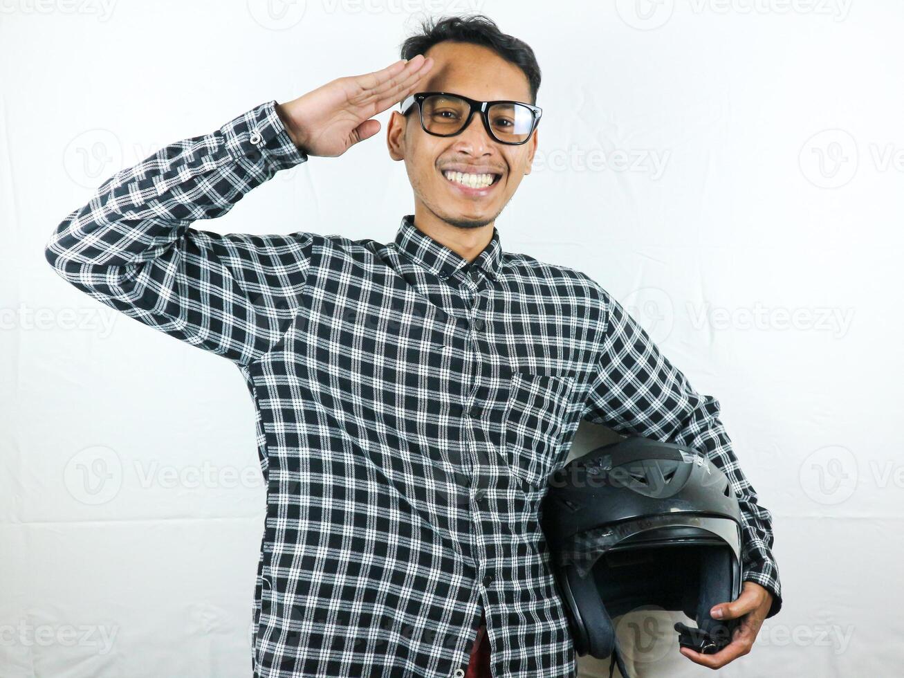 retrato ásia homem segurando motocicleta capacete com animado expressão. segurança cavalgando. foto