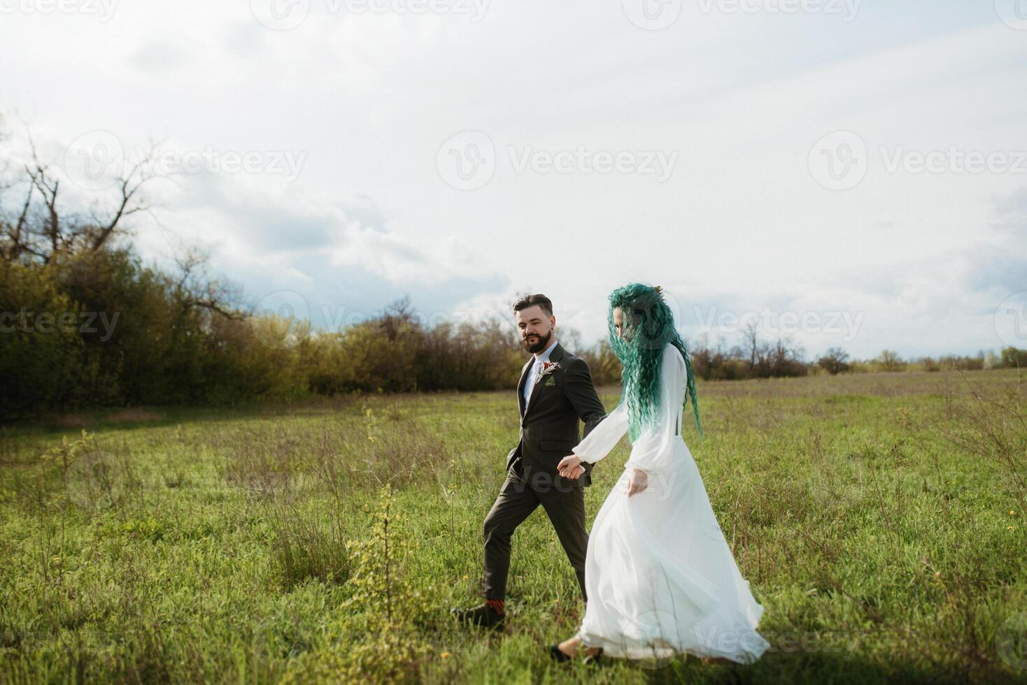 uma barbudo noivo e uma menina com verde cabelo dança e rodopio foto