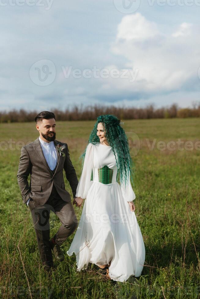 uma barbudo noivo e uma menina com verde cabelo dança e rodopio foto